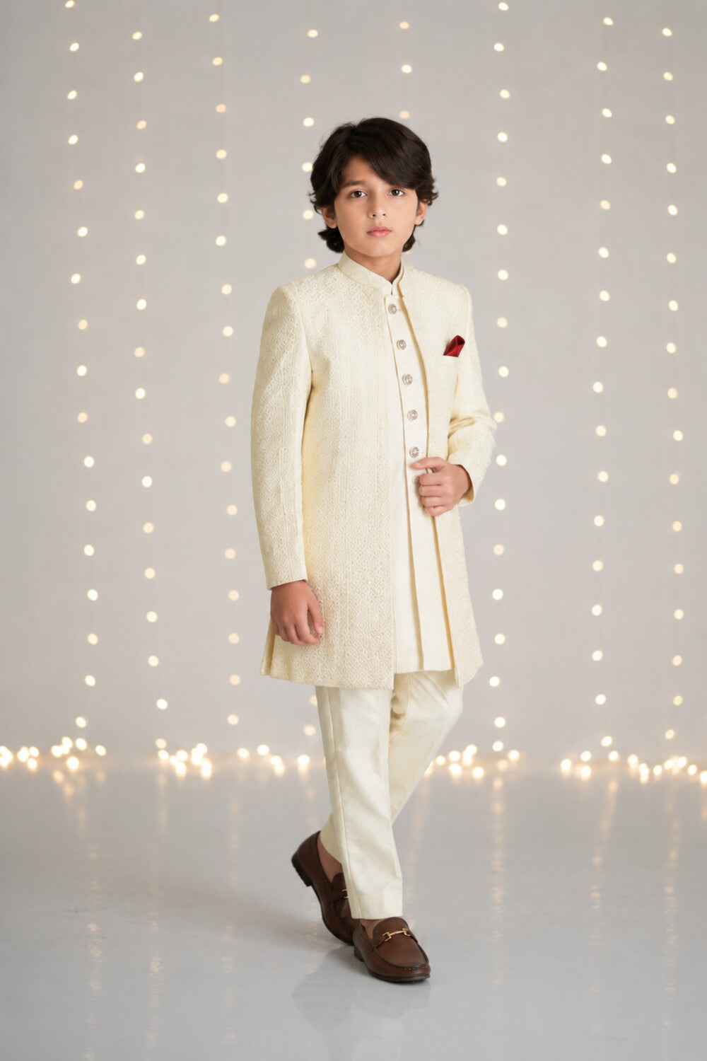 Boy wearing an ivory three-piece sherwani suit for weddings