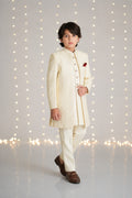 Boy wearing an ivory three-piece sherwani suit for weddings