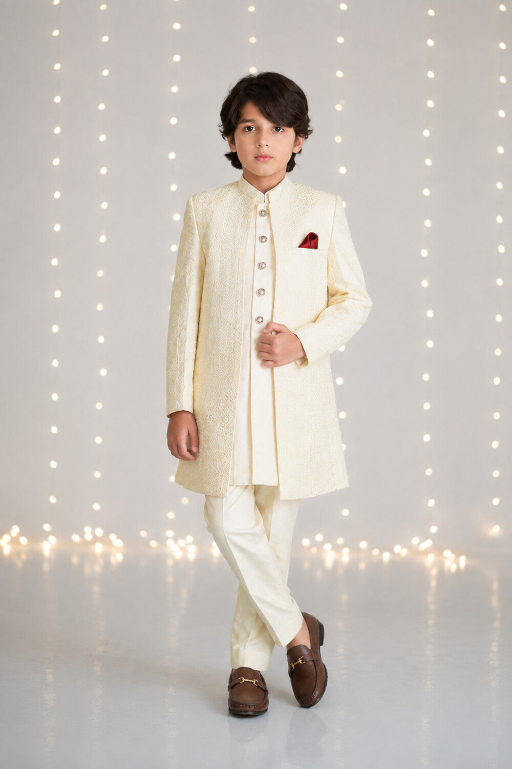 Boy wearing an ivory three-piece sherwani suit for weddings